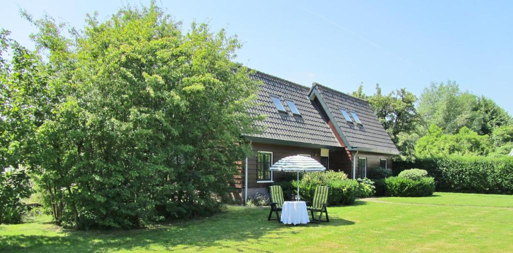 ein Haus mit einem Tisch und Stühlen im Hof in der Unterkunft Bed & Breakfast Kortenhoefsedijk in Kortenhoef