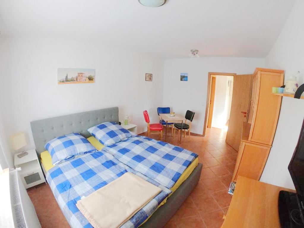 sypialnia z łóżkiem z niebiesko-białym kocem w obiekcie Ferienwohnung Simone w mieście Senftenberg