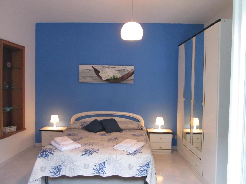a blue bedroom with a bed and two lamps at Casa Margherita in Minori