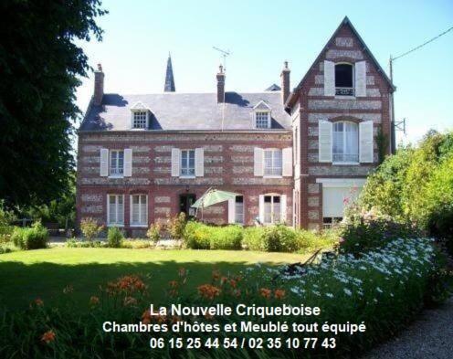 a large brick house with a sign in front of it at La Nouvelle Criqueboise in Criquebeuf-en-Caux