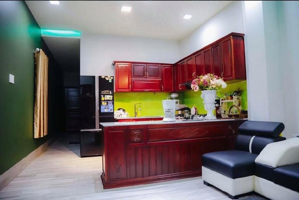 una cucina con armadi rossi e un divano in camera di Cozy furnished apartment in Phan Thiet city center a Phan Thiet