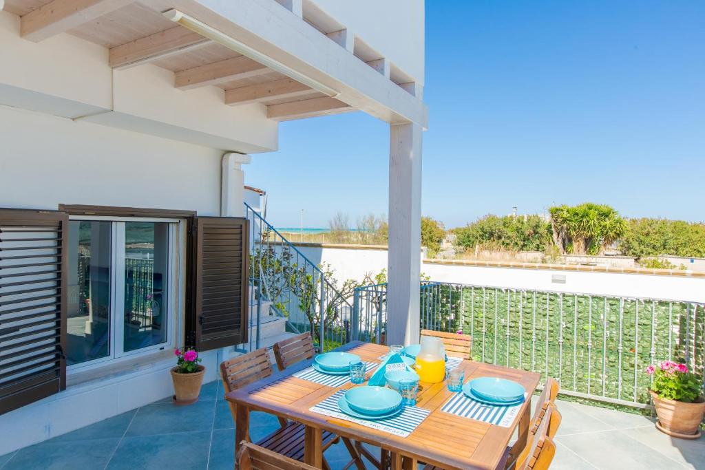 una mesa de madera en el balcón de una casa en Villa Laura vista mare, en Torre Santa Sabina