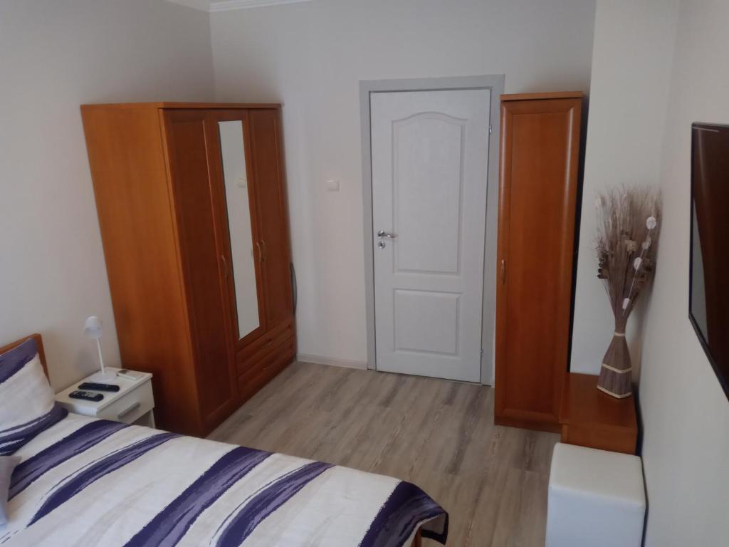 a bedroom with a bed and a wooden cabinet at Sweet Home in Burgas City