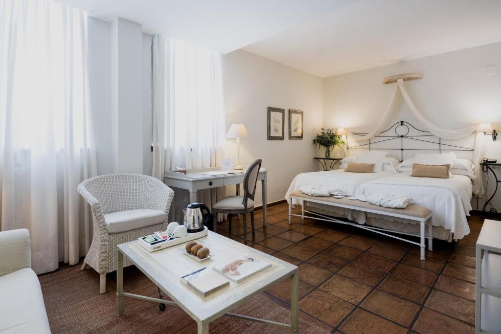 a bedroom with a bed and a desk and a table at Palacio De Los Navas in Granada