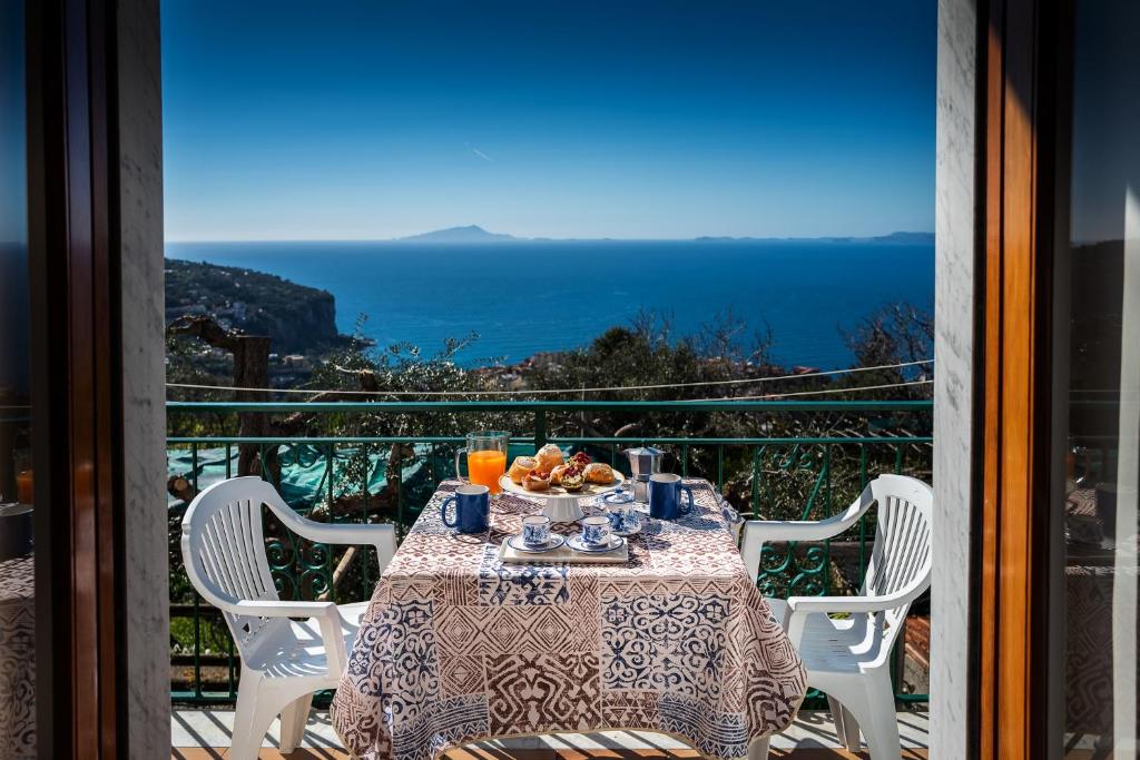 a table on a balcony with a view of the ocean at Casa Floriana in Vico Equense
