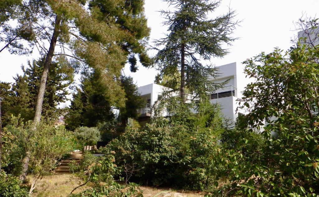 une maison blanche au milieu des arbres dans l'établissement Villa Lucienne Bandol , T2 4 étoiles avec garage, dans les calanques, à Bandol