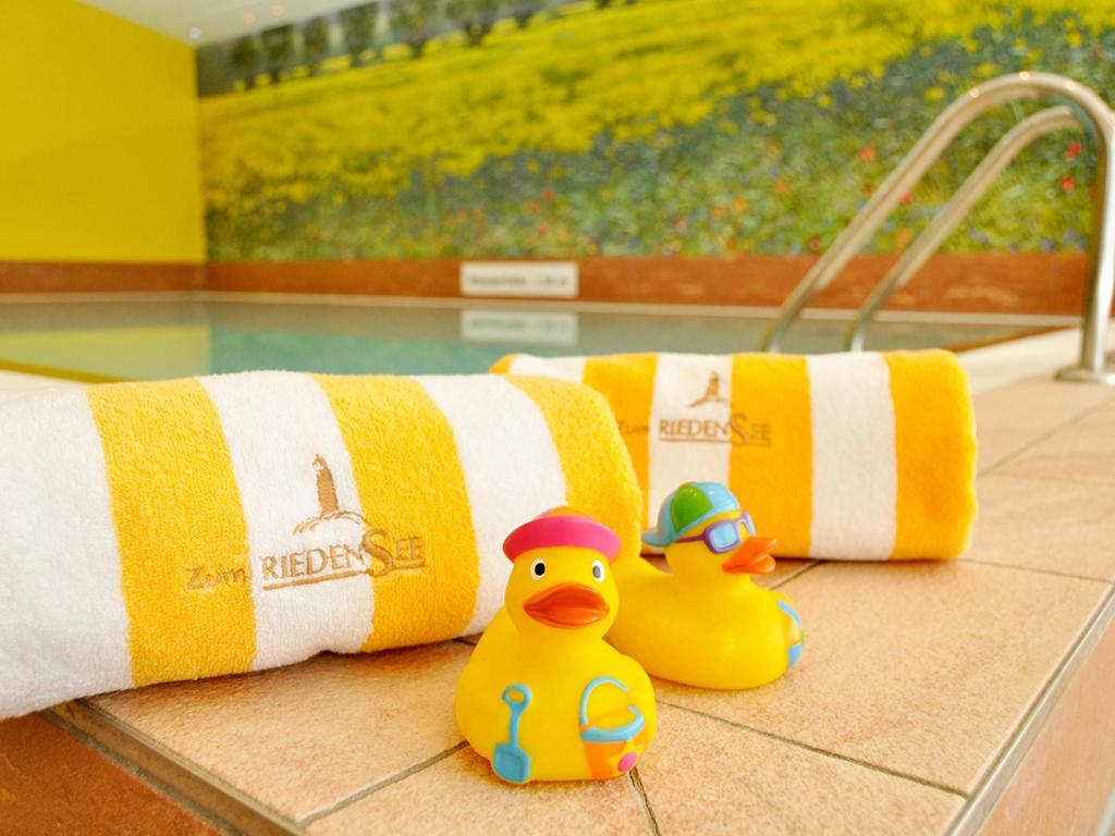 two rubber ducks sitting on the floor next to towels at Pension Zum Riedensee in Kühlungsborn