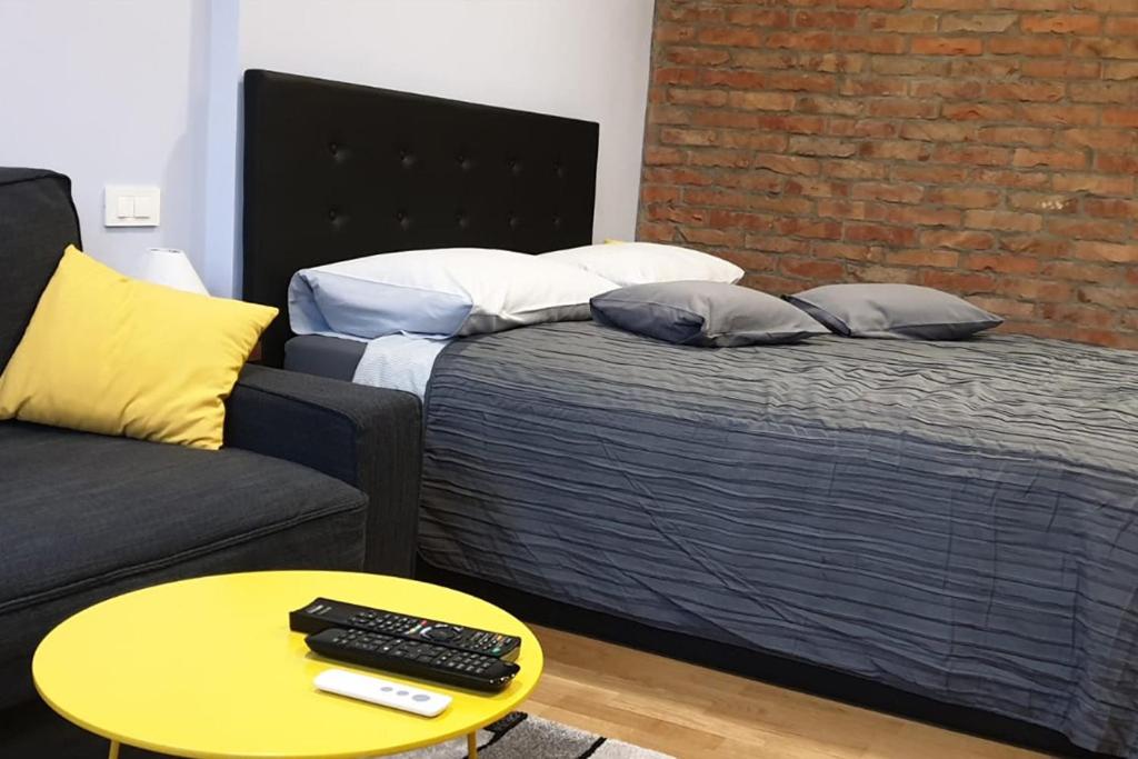 1 dormitorio con cama, sofá y mesa en Apartman Loen, en Zagreb