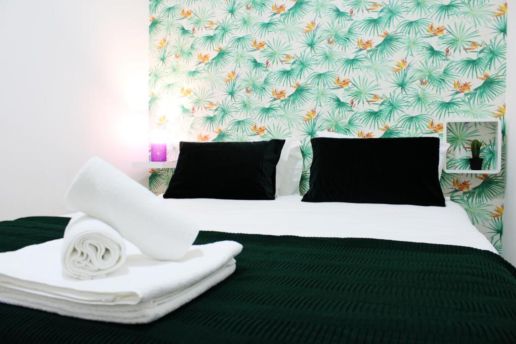 a bedroom with a white bed with black pillows at FeelCoimbra Apartamento Santa Cruz in Coimbra