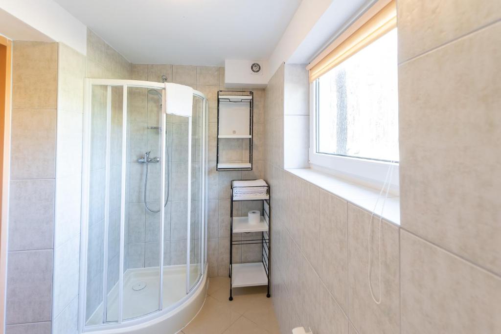 a bathroom with a shower and a window at Diuna in Międzywodzie