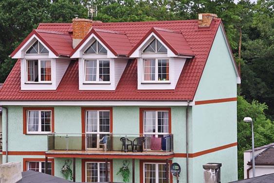 a large white house with a red roof at Helena in Karwia