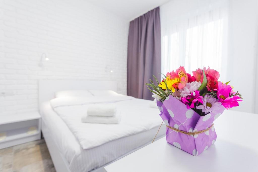 a bouquet of flowers sitting on a table in a bedroom at SkyHome na Nauky in Kyiv