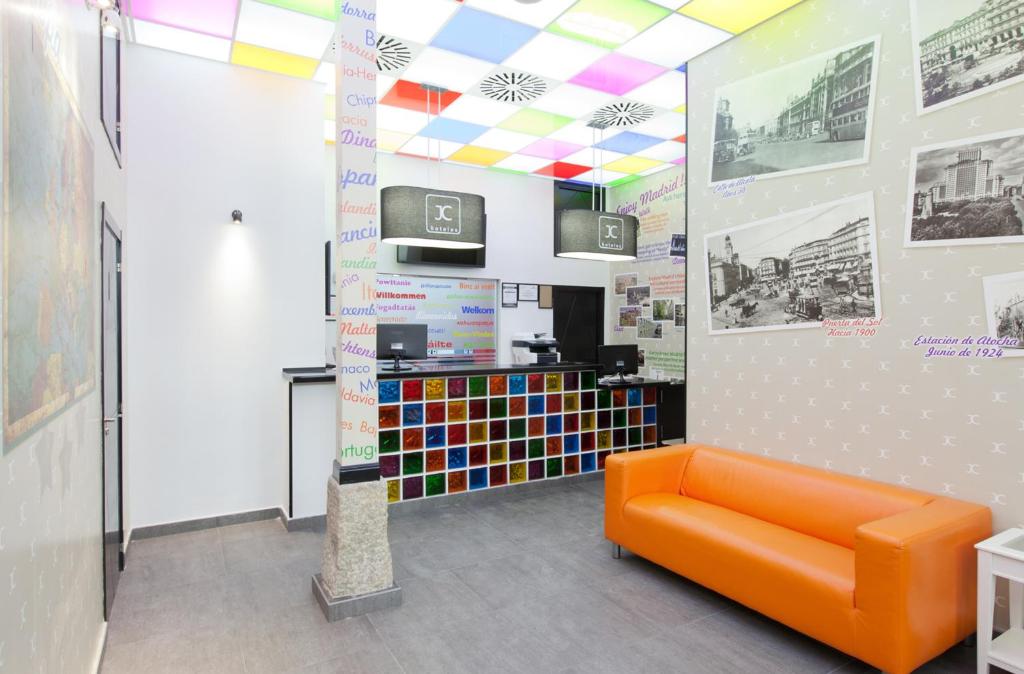 an orange couch in a room with a colorful ceiling at JC Rooms Santo Domingo in Madrid