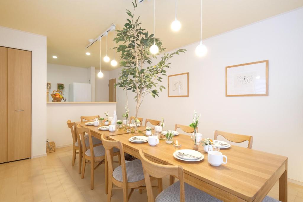 comedor con mesa de madera y sillas en Bremen House ~ブレーメンハウス~, en Yomitan