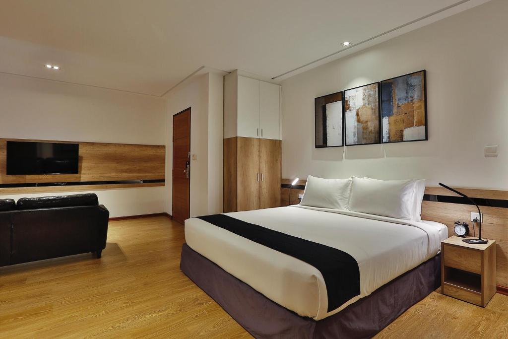 una camera d'albergo con un letto e un divano di K.C Hotel a Yangon