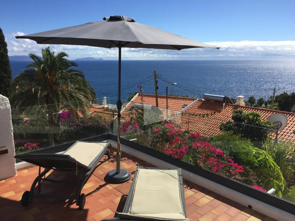 カニコにあるCasa Matschinegg Madeiraのパティオ(パラソル、テーブル、椅子付)