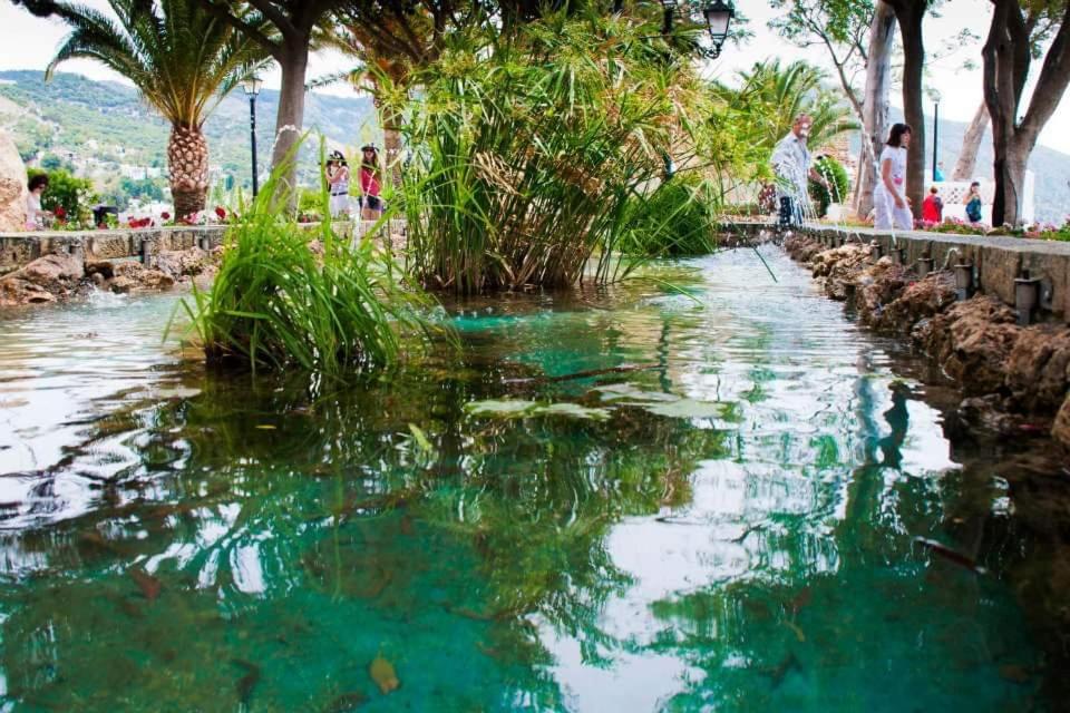 a body of water with trees and people walking around it at Valleverde Apartment in Mijas Costa