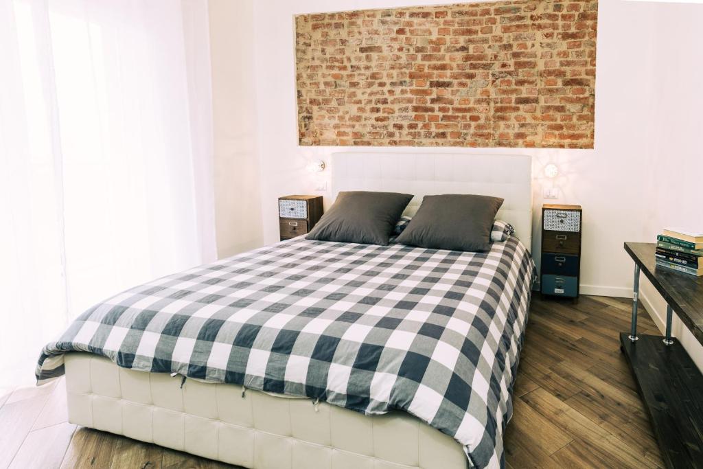 um quarto com uma cama xadrez em preto e branco em Mazzini 33 em Lainate