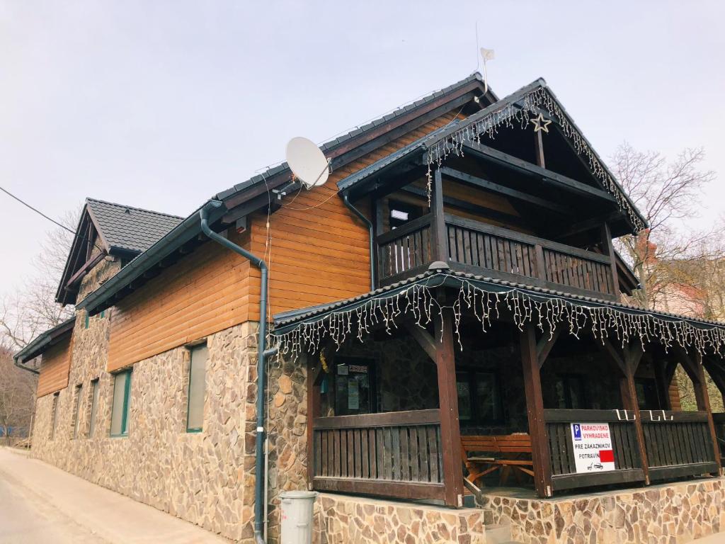 a wooden building with a sign on it at Apartmán pod orechom in Drienica