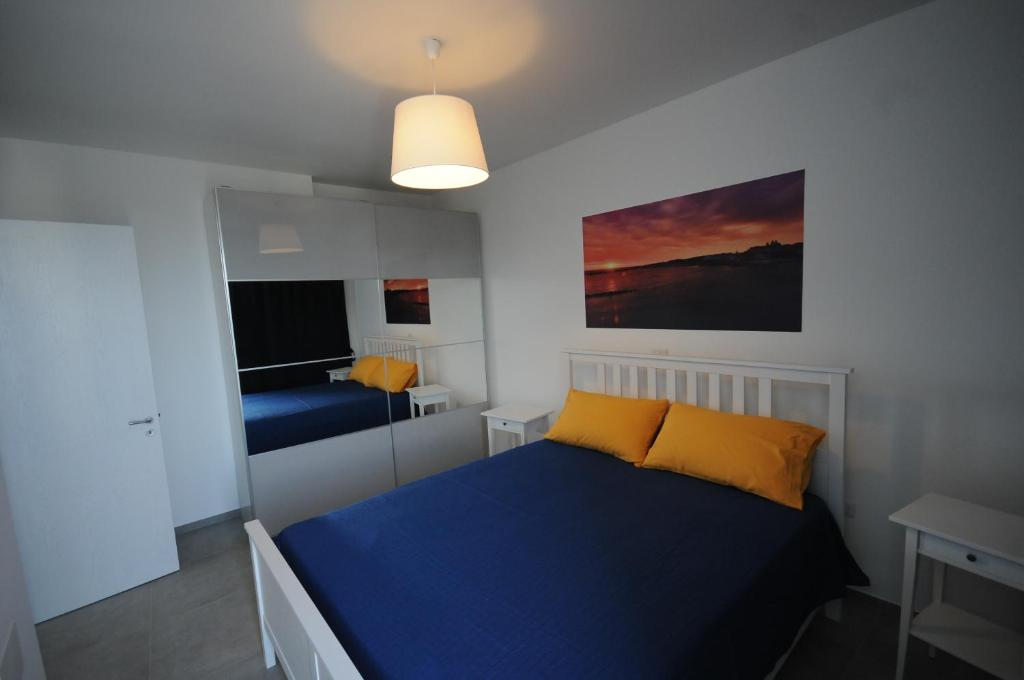 a bedroom with a blue bed with yellow pillows at Appartamenti porta mare in Otranto