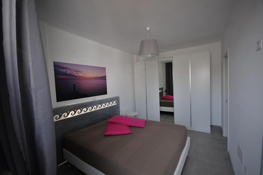 a bedroom with a brown bed with a television on the wall at Appartamenti porta mare in Otranto