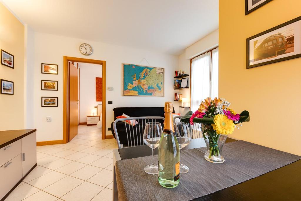 uma cozinha e sala de estar com uma mesa com copos de vinho em RomagnaBNB Stazione em Forlì