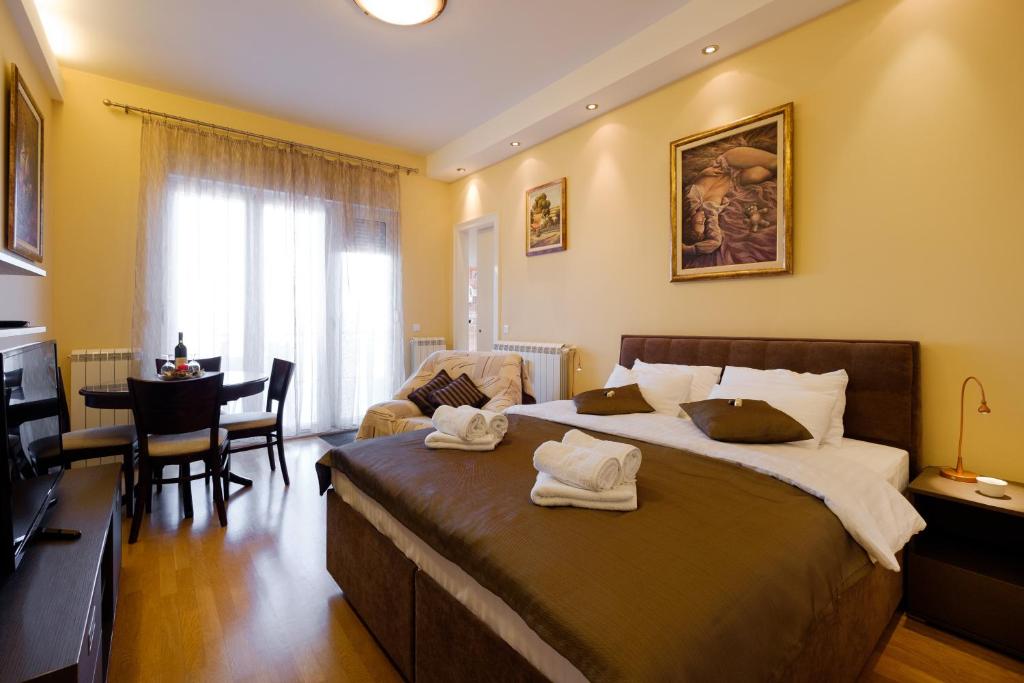 a bedroom with a large bed and a living room at Jolie in Belgrade