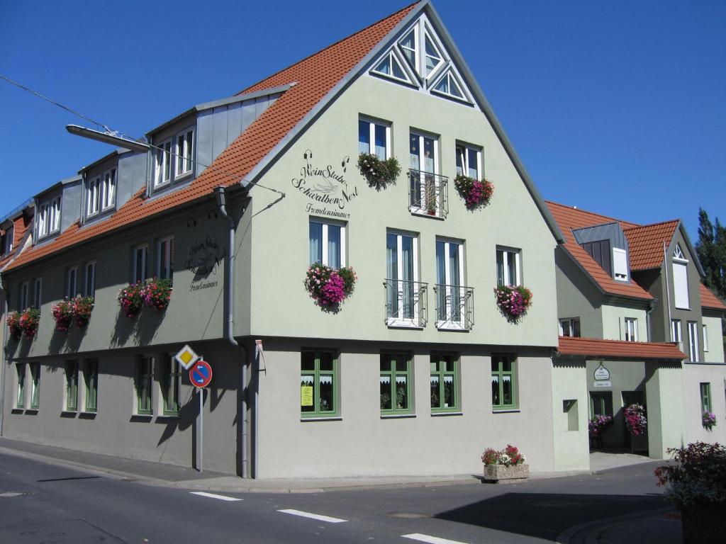 duży biały budynek z kwiatami na oknach w obiekcie Weinstube Schwalbennest w mieście Karlstadt