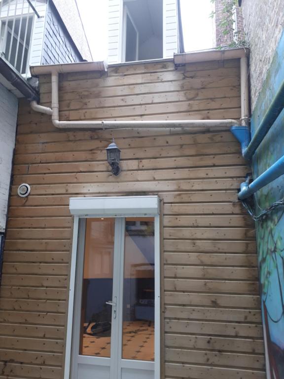 ein Holzgebäude mit einer Tür vor der Tür in der Unterkunft Ben & line in Mers-les-Bains