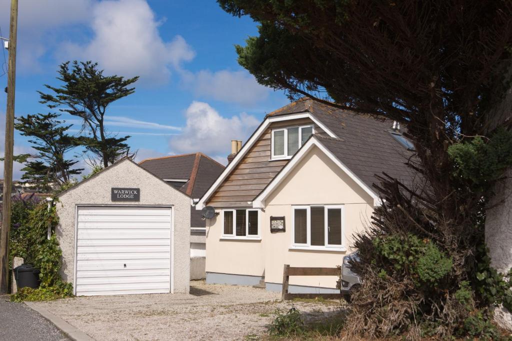 a white house with a garage at Warwick Lodge in Perranporth