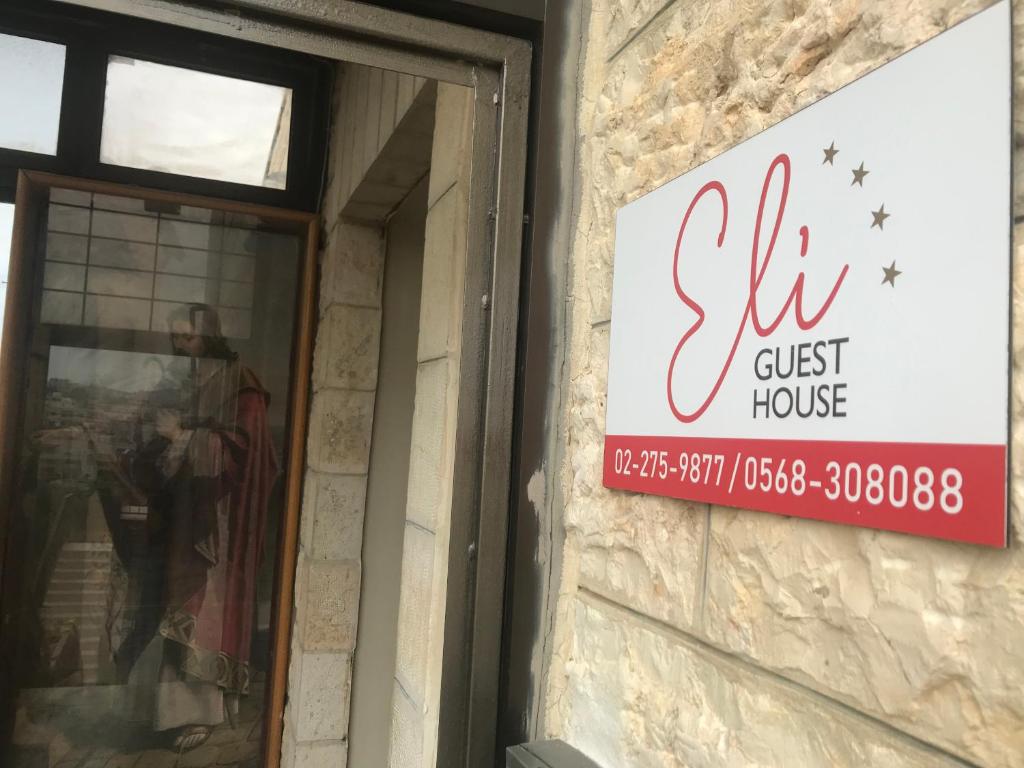 un letrero para una casa de huéspedes al lado de un edificio en Eli Guest House en Bethlehem