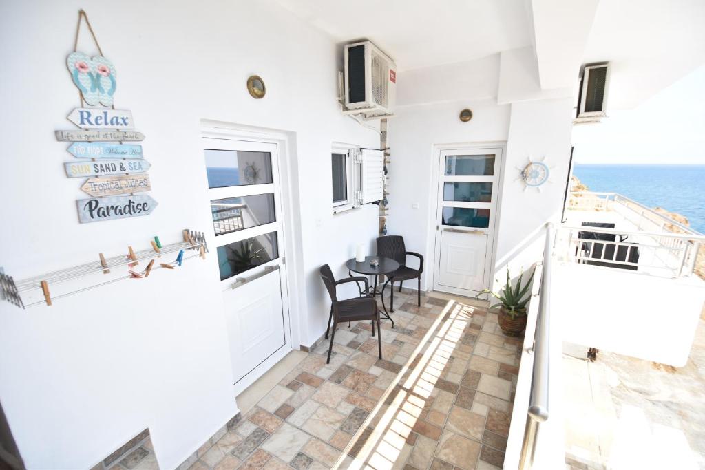 a balcony with a table and chairs and the ocean at House With View in Paránimfoi