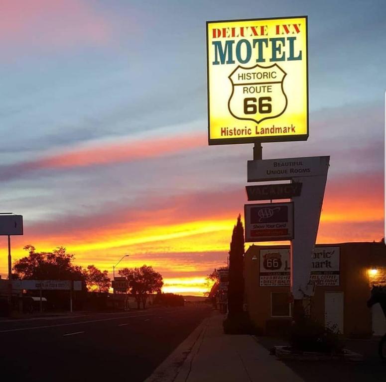 una gasolinera con una señal frente a una puesta de sol en Deluxe Inn, en Seligman