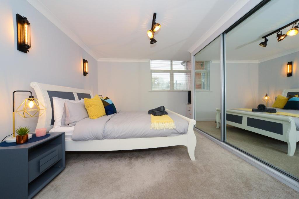 a bedroom with a white bed and a glass wall at Beautiful Apartment near Bournemouth, Poole & Sandbanks in Poole