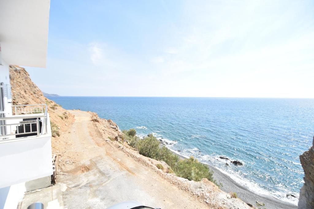 a dirt road next to the ocean on a cliff at House With View in Paránimfoi