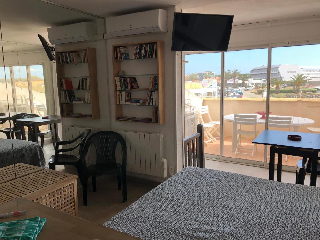 uma sala de estar com uma televisão na parede e uma varanda em Résidence Port Soleil B453 em Cap d'Agde