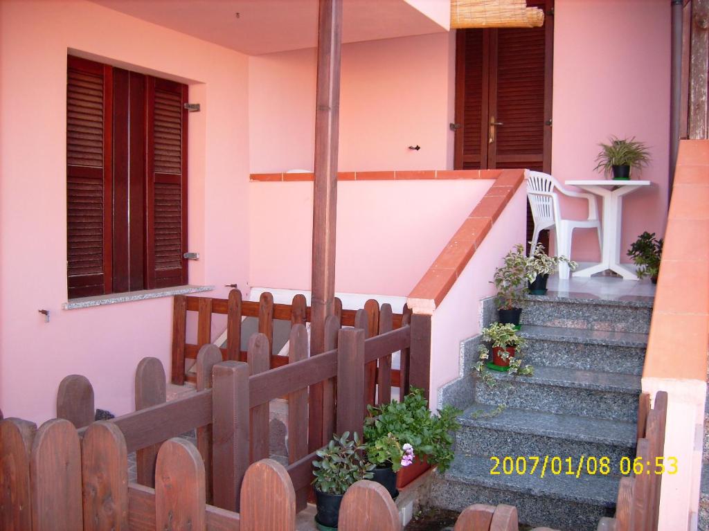 a house with stairs and a wooden fence at Monolocale a 200 metri dal mare in Funtana Meiga