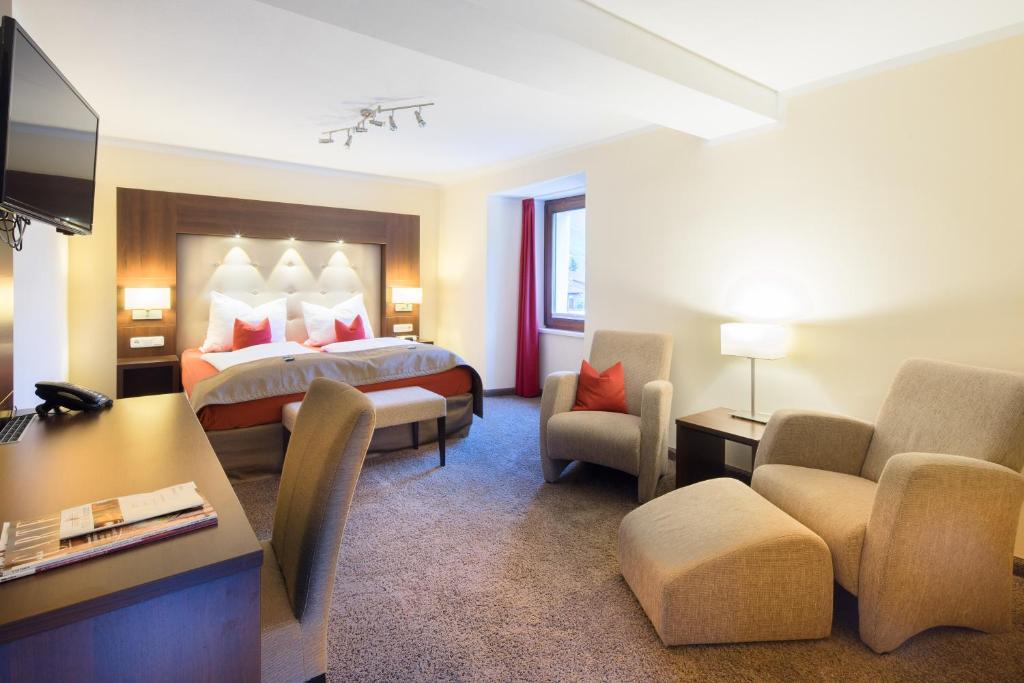 ein Hotelzimmer mit einem Bett und einem Schreibtisch in der Unterkunft Boutique Hotel Villa Melsheimer in Reil