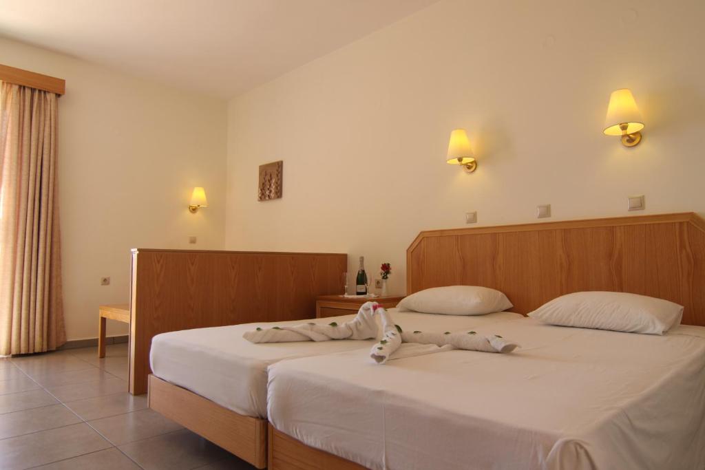 een slaapkamer met 2 bedden en witte lakens bij LINDOS HORIZON in Lindos