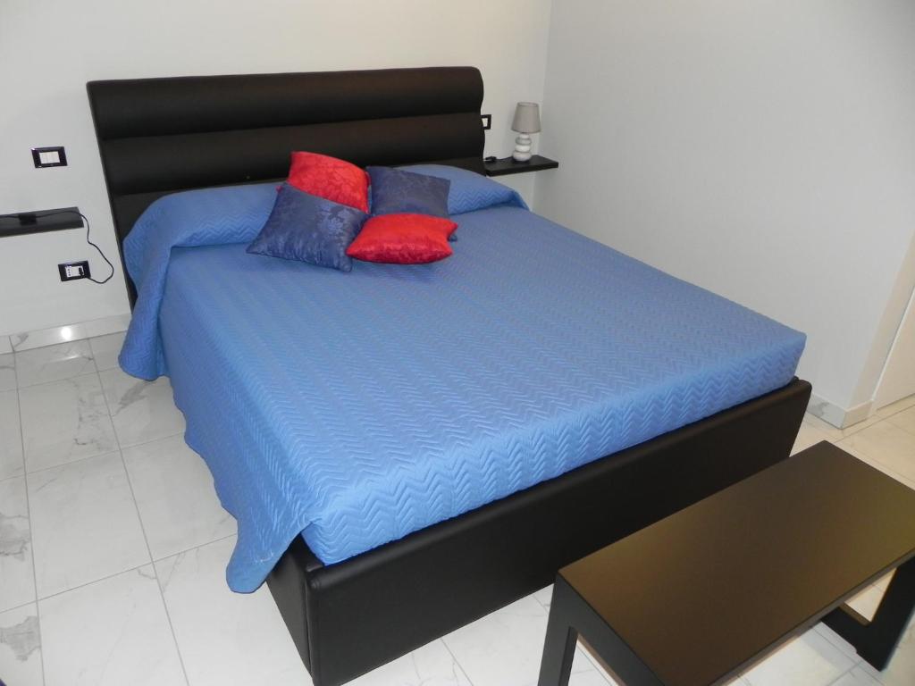1 cama con sábanas azules y almohadas rojas y azules en CASA DELLA ZIA ELSA, en Verona
