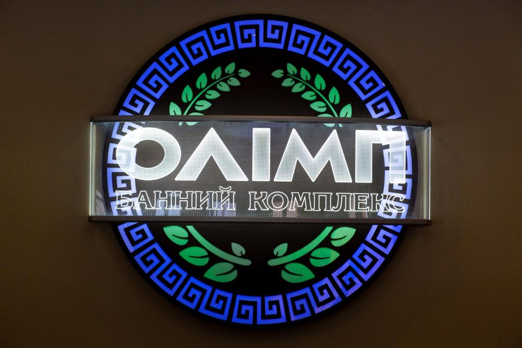 una señal en una pared con una señal redonda con la palabra examinador en Hotel Complex Olimp, en Uman