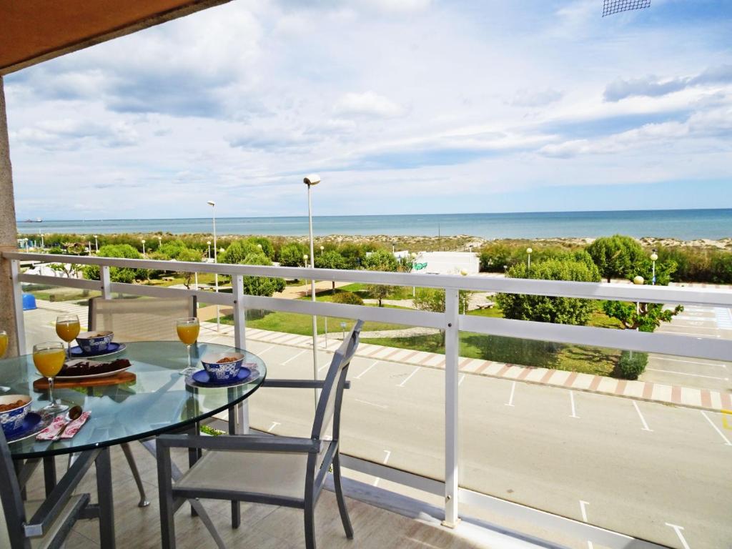 een balkon met een tafel en stoelen en de oceaan bij NEPTUNO Apartamento - Frente a la Playa in Daimús