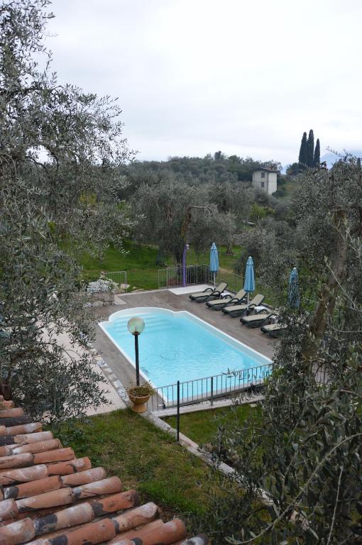 a swimming pool with lounge chairs and umbrellas at Appartamenti Ceccherini in Malcesine