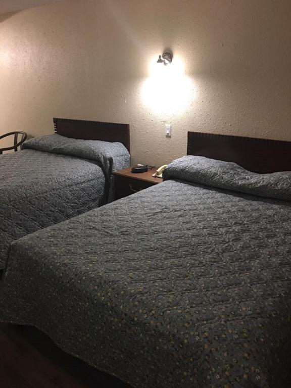 Postel nebo postele na pokoji v ubytování Red Deer Inn & Suites