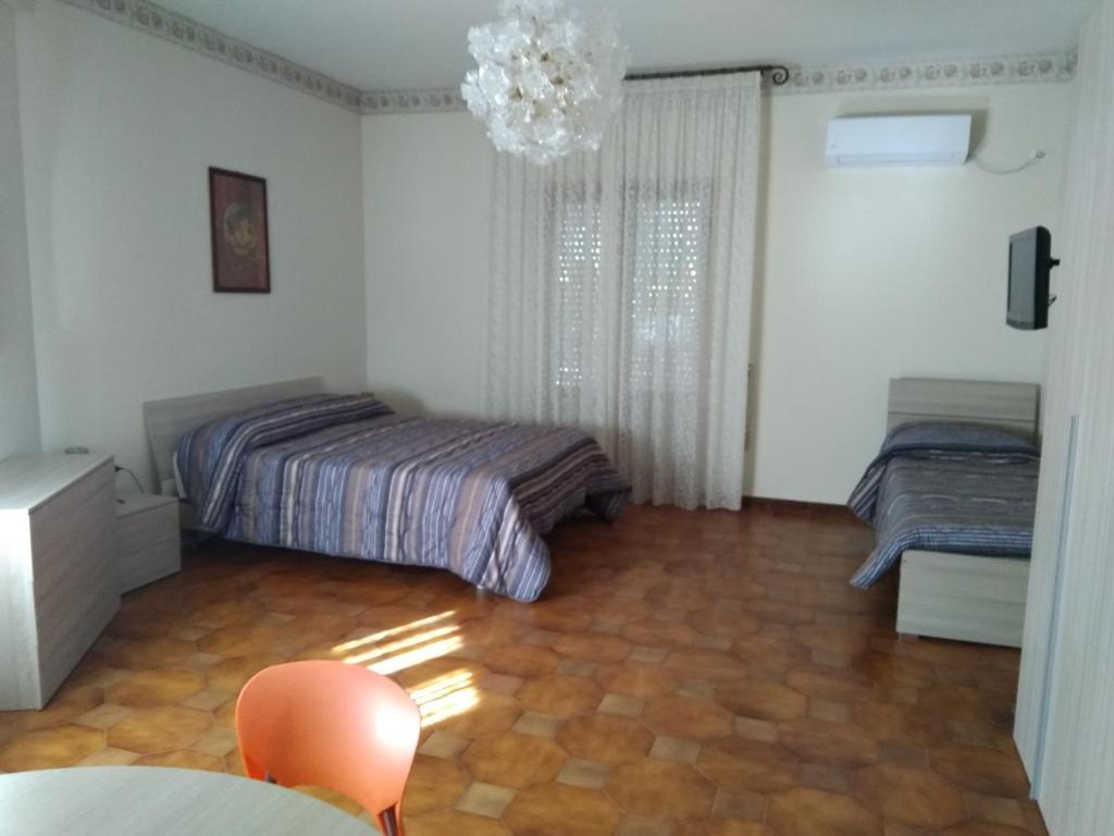 a bedroom with two beds and a chandelier at Federico's House in Ercolano