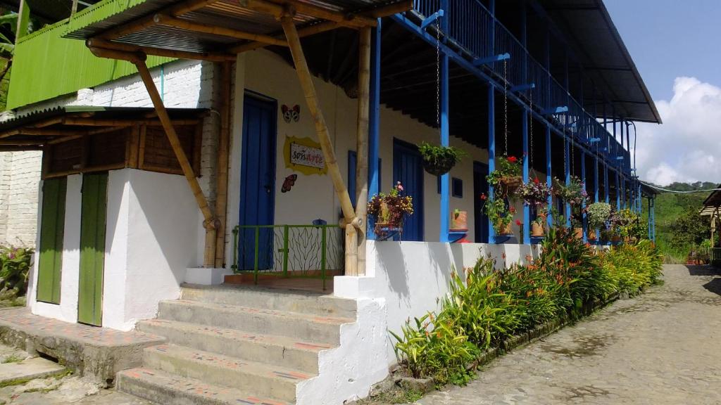 um edifício com portas azuis, escadas e flores em Soñarte Reserva Natural em Córdoba