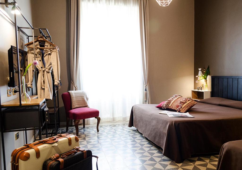 ローマにあるEterna Romaのベッドルーム1室(ベッド1台、椅子、窓付)