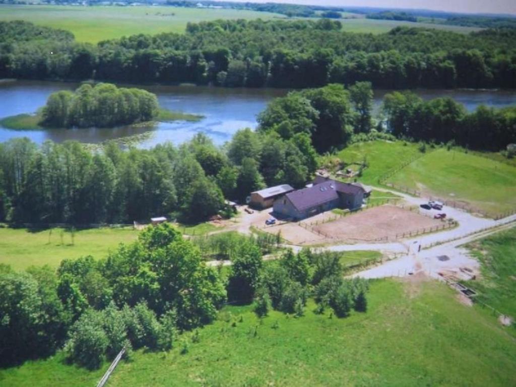 an aerial view of a house next to a river at Stajnia Grazyny Mikorowo 46 in Czarna Dąbrówka