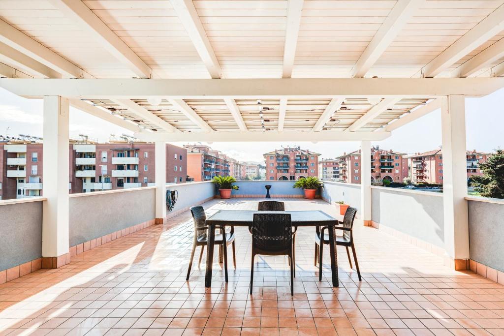 a patio with a table and chairs on a roof at Anagnina Apartment in La Romanina