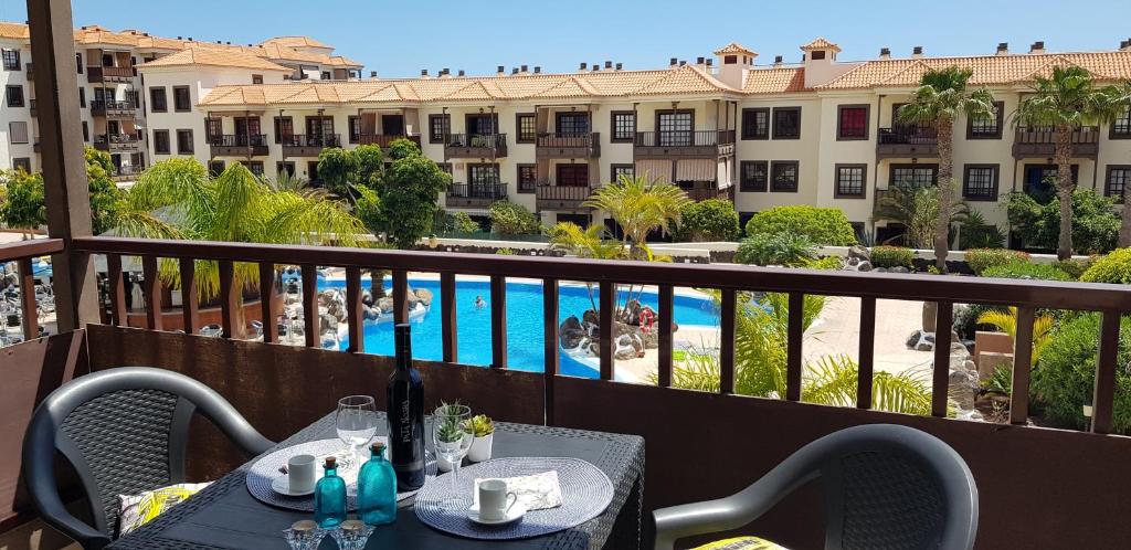 a balcony with tables and chairs with a view of a pool at Balcon Del Mar Luxury Suite in Costa Del Silencio